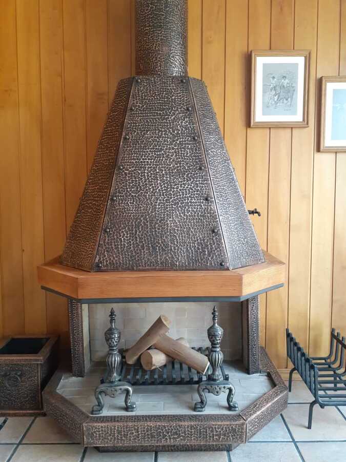 chimenea cobre martillado con madera
