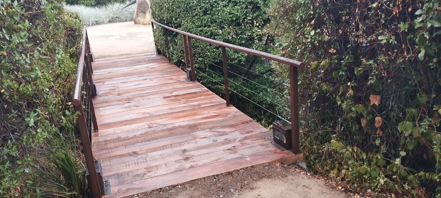Puente de durmientes con pasamanos envejecido.