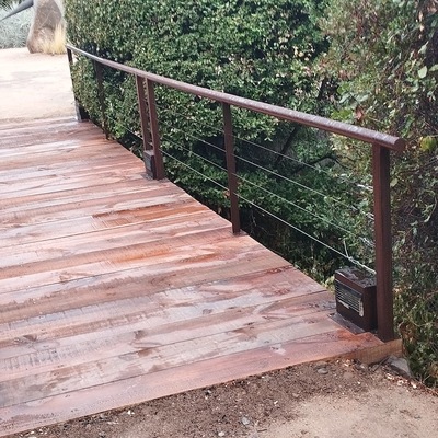 Puente de durmientes con pasamanos envejecido.