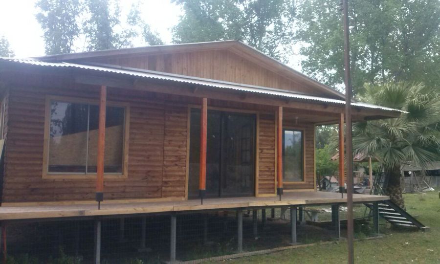 Acceso , vivienda sobre pilotes de rollizo