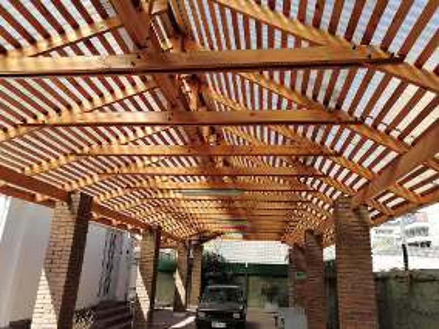 Cobertizo de madera  con vigas a la vista. .