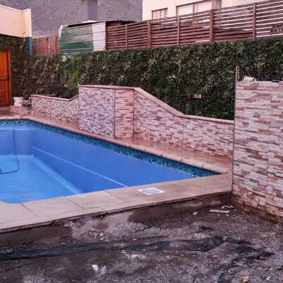 piscina de 9  metros con terminación de pastelones de 50 y cascada