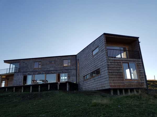 fachada exterior con tejuela de alerce y terminaciones de mañío