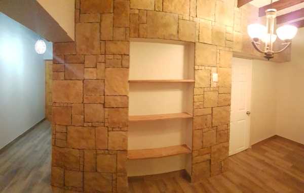 Revestimiento de piedra en muro y repisas en madera de Radal